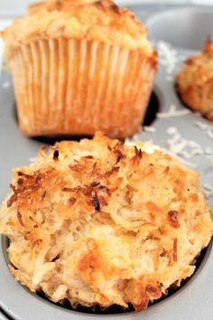 two muffins sitting on top of a plate next to other muffins