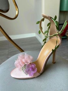 Step into a garden of elegance with the Claire Floral Heels. These stunning heels feature a delicate pink base adorned with intricate floral details, making them the perfect accessory for a romantic and feminine look. The ankle strap is beautifully decorated with green leaf accents, adding a whimsical touch that complements the soft, ethereal flowers on the toe. Crafted with a satin finish, the Claire Floral Heels offer a luxurious feel and a comfortable fit. The open-toe design showcases your p Pink Wedding Heels, Ethereal Flowers, Stunning Heels, Formal Accessories, Floral Sandals, Floral Heels, Heels Outfits, Floral Shoes, Flower Lights