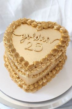 a heart - shaped cake with the word golden on it sits on a platter