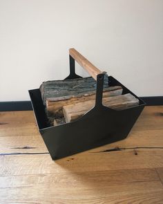 a firewood log holder on top of a wooden floor