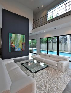 a living room with white furniture and large windows