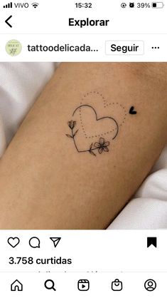 a small tattoo on the arm of a person with a heart and flowers in it