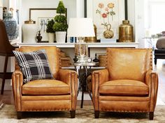 two brown leather chairs sitting next to each other