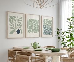 a dining room table with chairs and plates on it in front of three framed art pieces