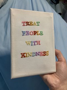 someone is holding up a book with the words treat people with kindness written on it