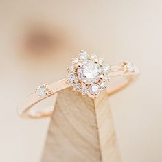 a diamond ring sitting on top of a wooden stand