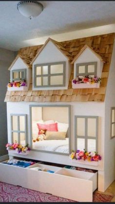 there is a doll house made out of cardboard and flowers on the roof with windows