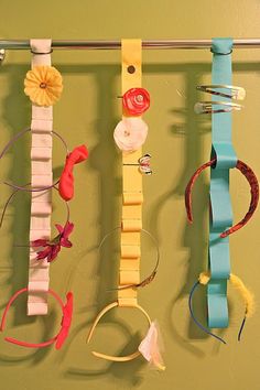 several different types of ribbons hanging on a wall with clothes pins attached to the strings