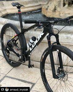 a black and white bike parked next to a fountain