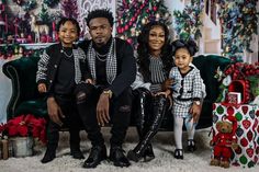 a family sitting on a couch in front of christmas decorations