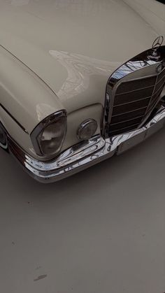 an old fashion car is parked in a parking lot with its hood up and headlight on