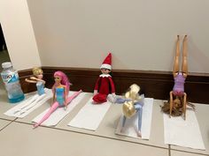 elf dolls are lined up on yoga mats