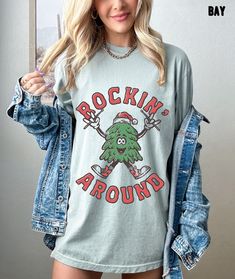 "Rockin' Around Oversized Christmas Shirt, Christmas Tree Retro Shirt, Rockin' Around Christmas Vintage Shirt, Comfort Colors Christmas Shirt Whether you're hitting the road for a cross-country adventure or just hanging out with friends, you'll love its comfortable, oversized fit with this Comfort Colors shirt. The mineral wash feel is super soft and perfect for any casual occasion. Rock this tee with your favorite jeans or leggings and you'll look great no matter what. This is a standard unisex size Comfort Colors Tee. For an oversized tee, please size up. If you are looking for an oversized \"T-shirt Dress\" look, we recommend sizing up 2 sizes. Please review the size chart to ensure you receive the fit you want. HOW TO ORDER 1- Select \"Shirt Size\". 2- Select quantity. 3- Click \"Add T Christmas Tree Retro, Rockin Around The Christmas Tree, Christmas Tree Costume, Oversized T Shirt Dress, Christmas Tree Shirt, Tree Shirt, Comfort Colors Shirt, Christmas Vintage, Comfort Colors Tee