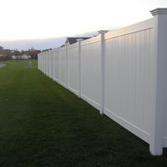 a white fence in the middle of a grassy field