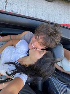 two people are sitting in the back of a car and one person is hugging her head