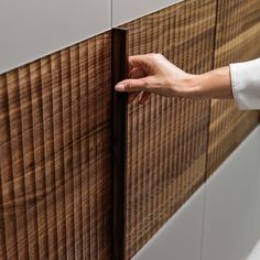 a person's hand is holding onto the side of a wooden paneled wall