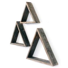 three wooden triangle shaped shelves on a white wall, one is made out of wood