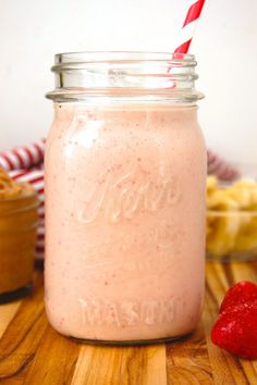 a strawberry smoothie in a mason jar with a straw