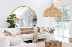 a living room filled with furniture and a large round mirror