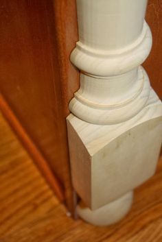 a close up of a wooden door with a white pillar on the front and side