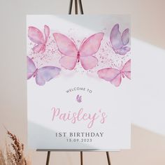 a welcome sign with pink butterflies on it and the words,'welcome to paisley's 1st birthday '