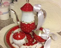 a red and white tea set sitting on top of a plate