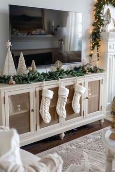 a living room decorated for christmas with stockings on the fireplace