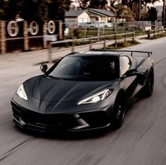 a black sports car driving down the road