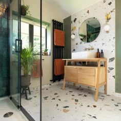 a bathroom with a sink, mirror and plants