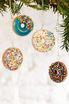 three doughnuts hanging from a christmas tree with sprinkles on them