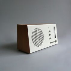 an old fashioned radio sitting on top of a gray table next to a white wall