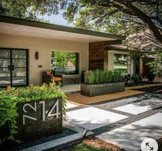 a house with plants in the front yard and number 414 on the outside wall