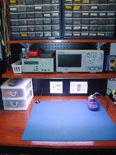 there is a blue mat on the desk next to an electrical device and other items