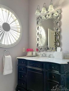 a bathroom with a sink, mirror and fan in it's centerpieces