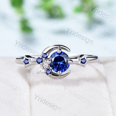 an engagement ring with a blue sapphire and diamond accents on the side, set in white gold