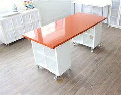 a kitchen with white cabinets and an orange counter top on wheels in front of it