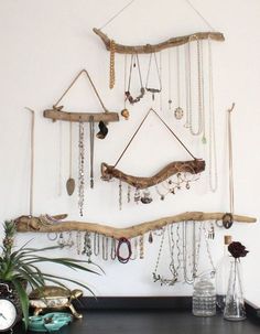 there is a wall hanging made out of branches and jewelry on it's side