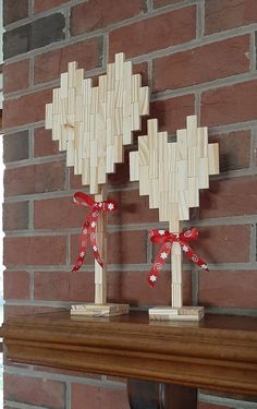 two wooden crosses are placed on top of a mantel in front of a brick wall