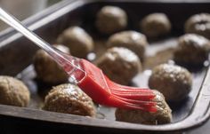 a red spatula is being used to make meatballs