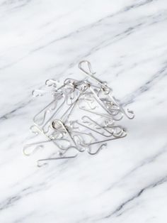 several pieces of metal wire sitting on top of a white marble surface