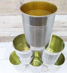 four metal cups are stacked on top of each other