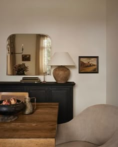 a living room with a table, chair and mirror