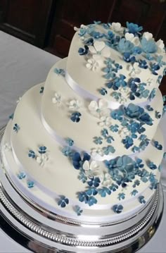 a wedding cake with blue and white flowers on it