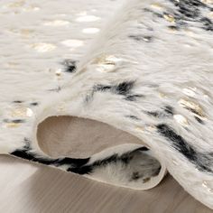 a white and black rug with gold dots on it