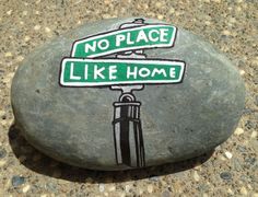 there is a rock painted with street signs on it that says no place like home