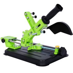 a machine that is sitting on top of a black tray with green trimming tools