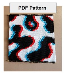 a crocheted square with red, white and blue designs on it's side