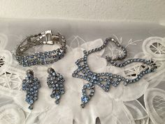 This is a Stunning 1950's Faceted and Pronged Ice Blue Rhinestone Parure.  Choker Necklace 14 Inches Long with 2 Inch Front Hang Down. Clip on Earrings 1 3/4 inches Long and a Bracelet 6 1/2 Inches before the Clamp over Closure and 3/4 Inches Wide.  This is a Stunning Set and Ready to Wear.  Beautifully made and a Perfect Wedding Set.  Beautiful Blue!  ON SALE NOW! WAS AT $78.00....  SHIPS TO U. S. ONLY.... Vintage Blue Rhinestone Jewelry, Blue Moonstone, Wedding Set, Wedding Jewelry Sets, Blue Rhinestones, Necklace Bracelet, Ice Blue, Earrings Set, Beautiful Blue