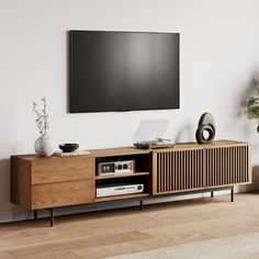 an entertainment center with a flat screen tv mounted on the wall and wooden furniture in front of it