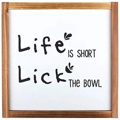 a sign that says life is short, lick the bowl on white paper with black lettering